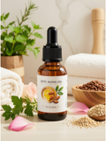 An amber glass dropper bottle labeled 'ANTI AGING OIL' stands on a light surface with rolled towels, green leaves, pink petals, and small bowls of seeds around it.